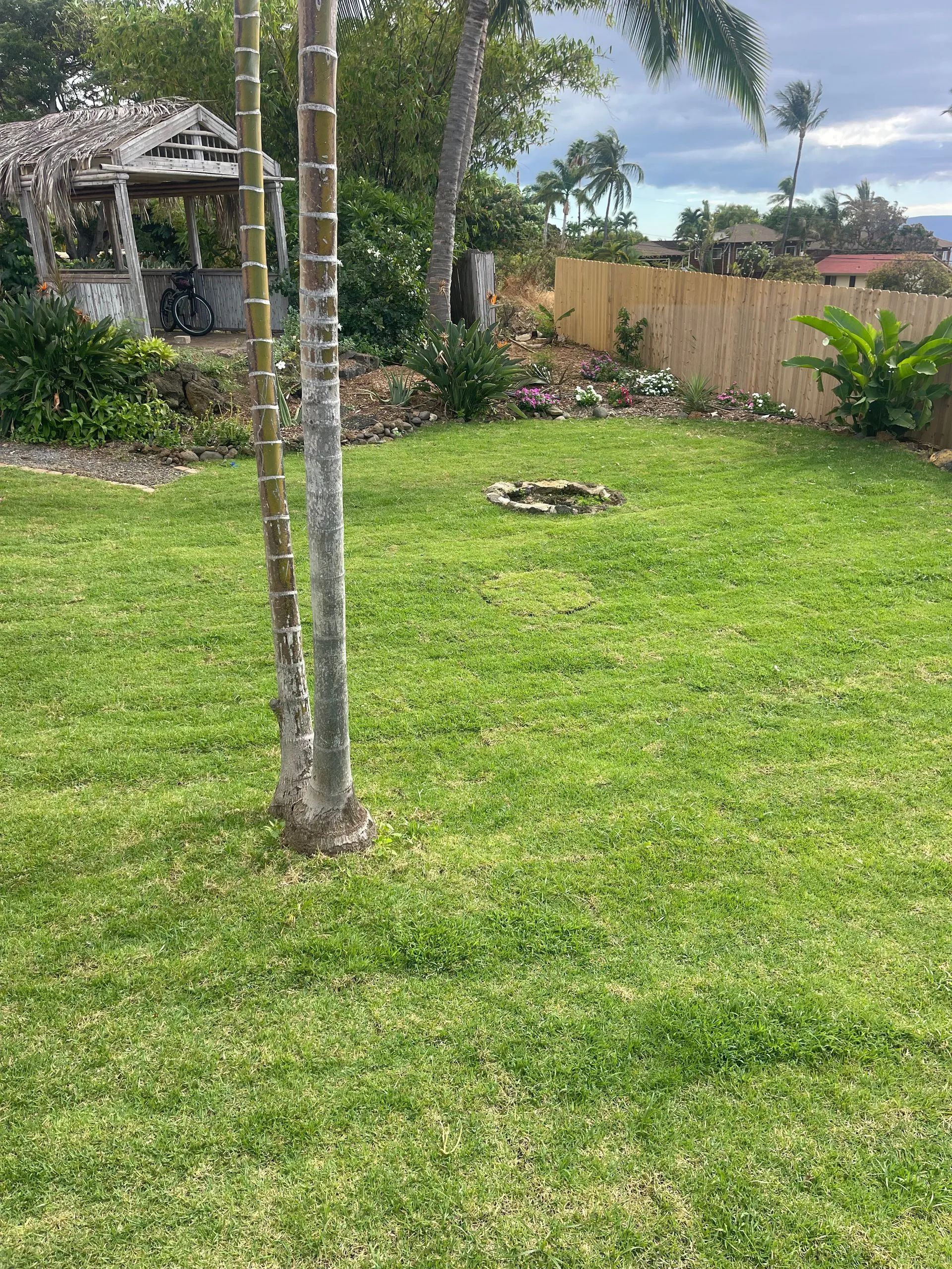 A large lush green lawn with a gazebo in the background.