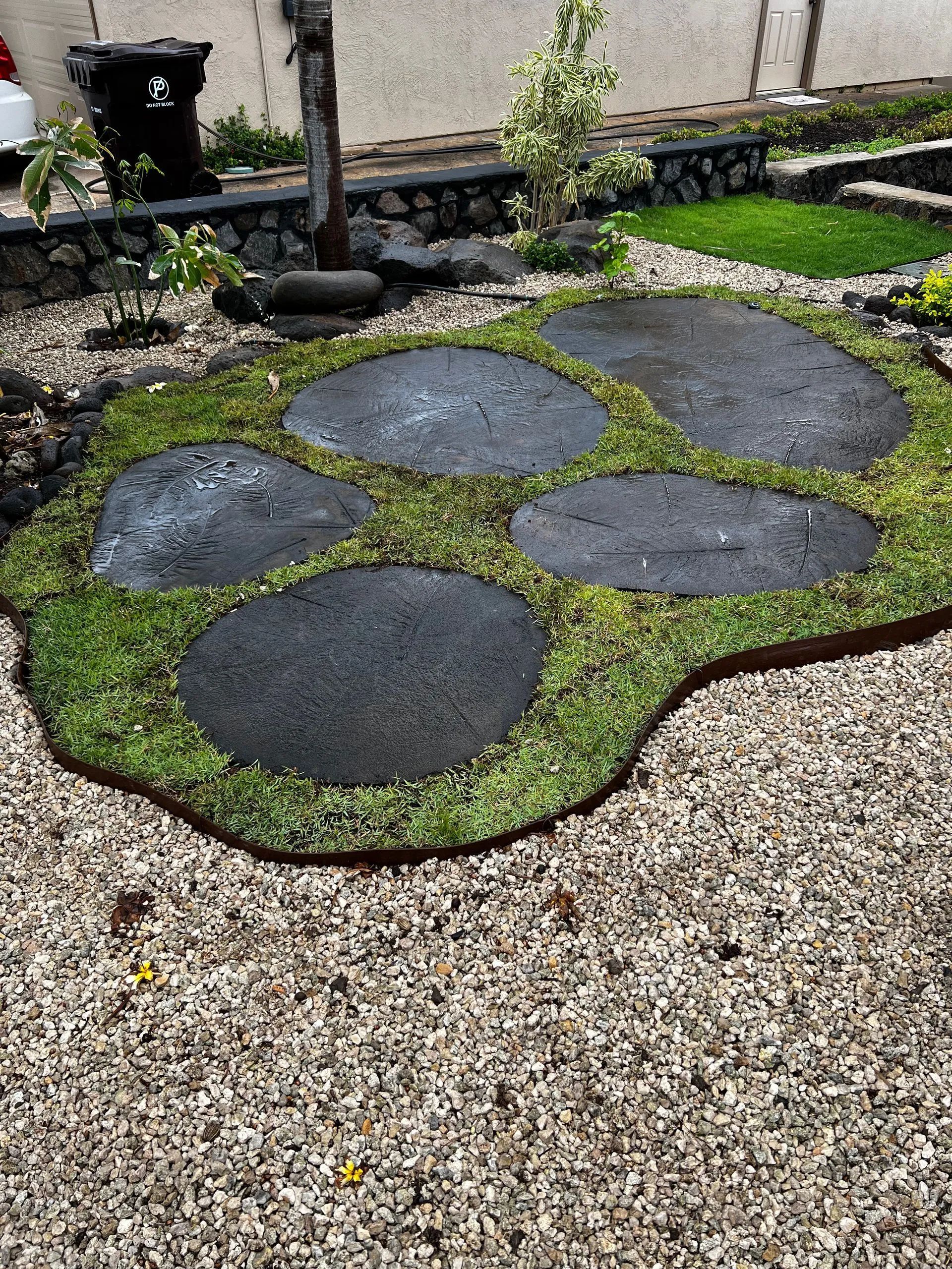 A garden with rocks and grass in the shape of a paw print.