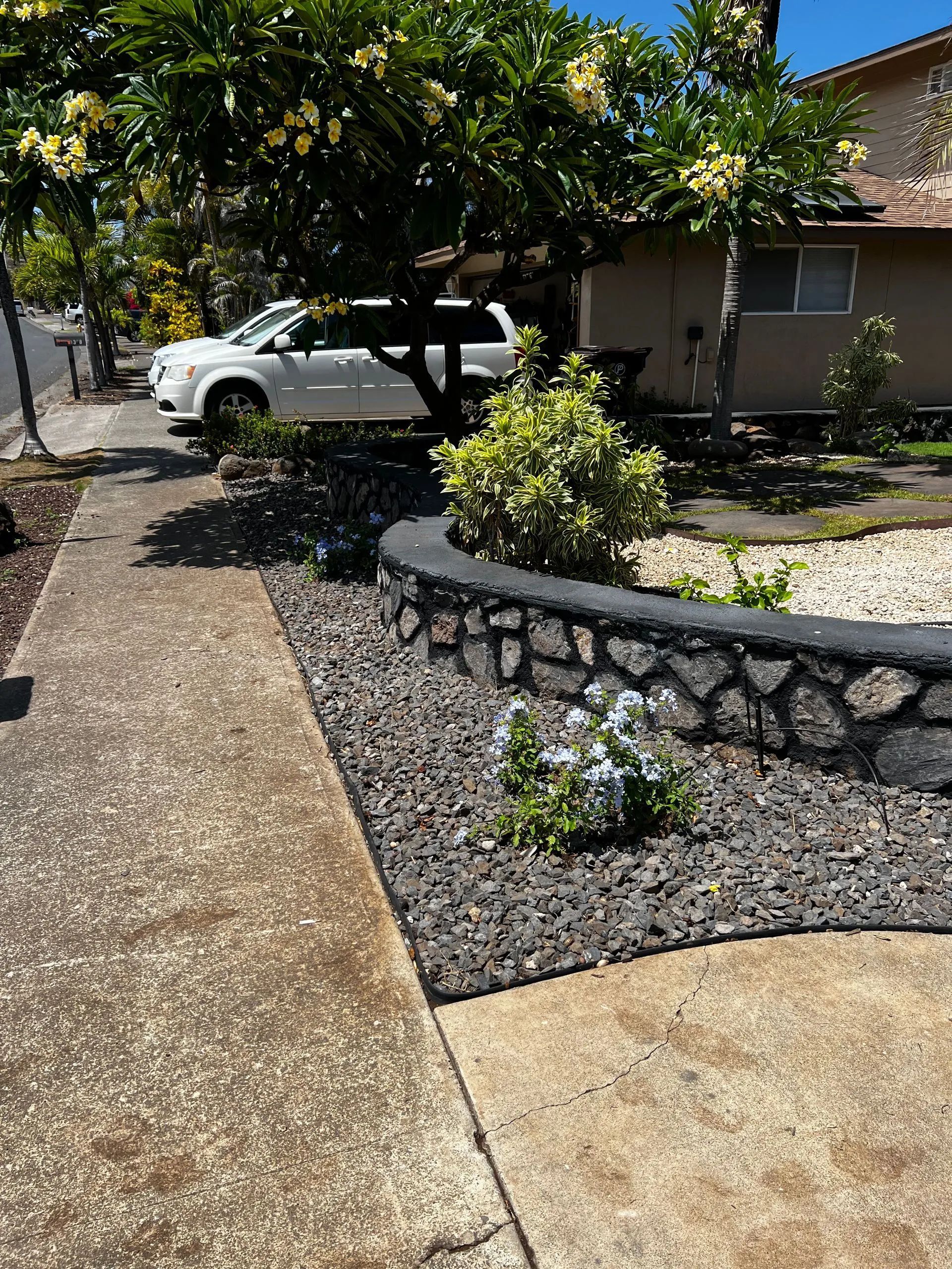 A white van is parked on the side of the road in front of a house.
