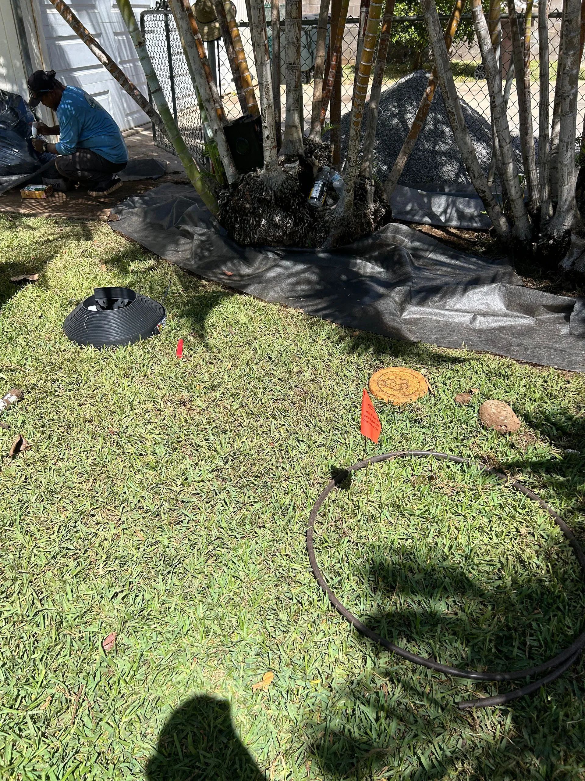 A man is working on a drain in the grass.