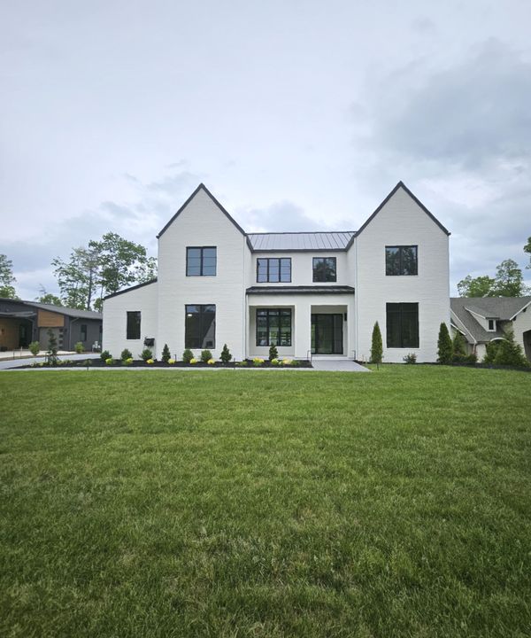 A large white house with a large lawn in front of it.