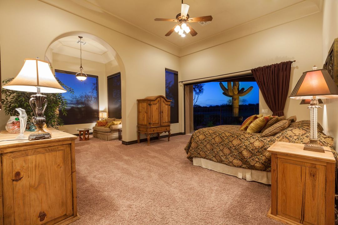 A bedroom with a large bed and a ceiling fan.