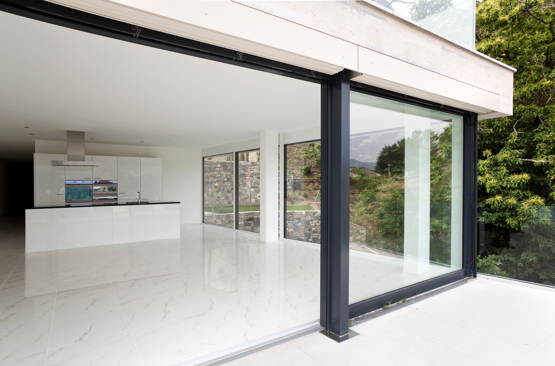 An empty house with a lot of windows and a sliding glass door.