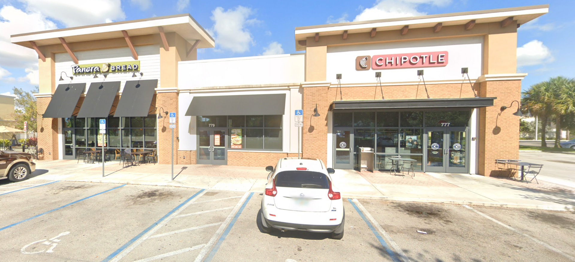 Exterior view of a building with two businesses: Capital Sushi and Del Taco. Bright, sunny day.
