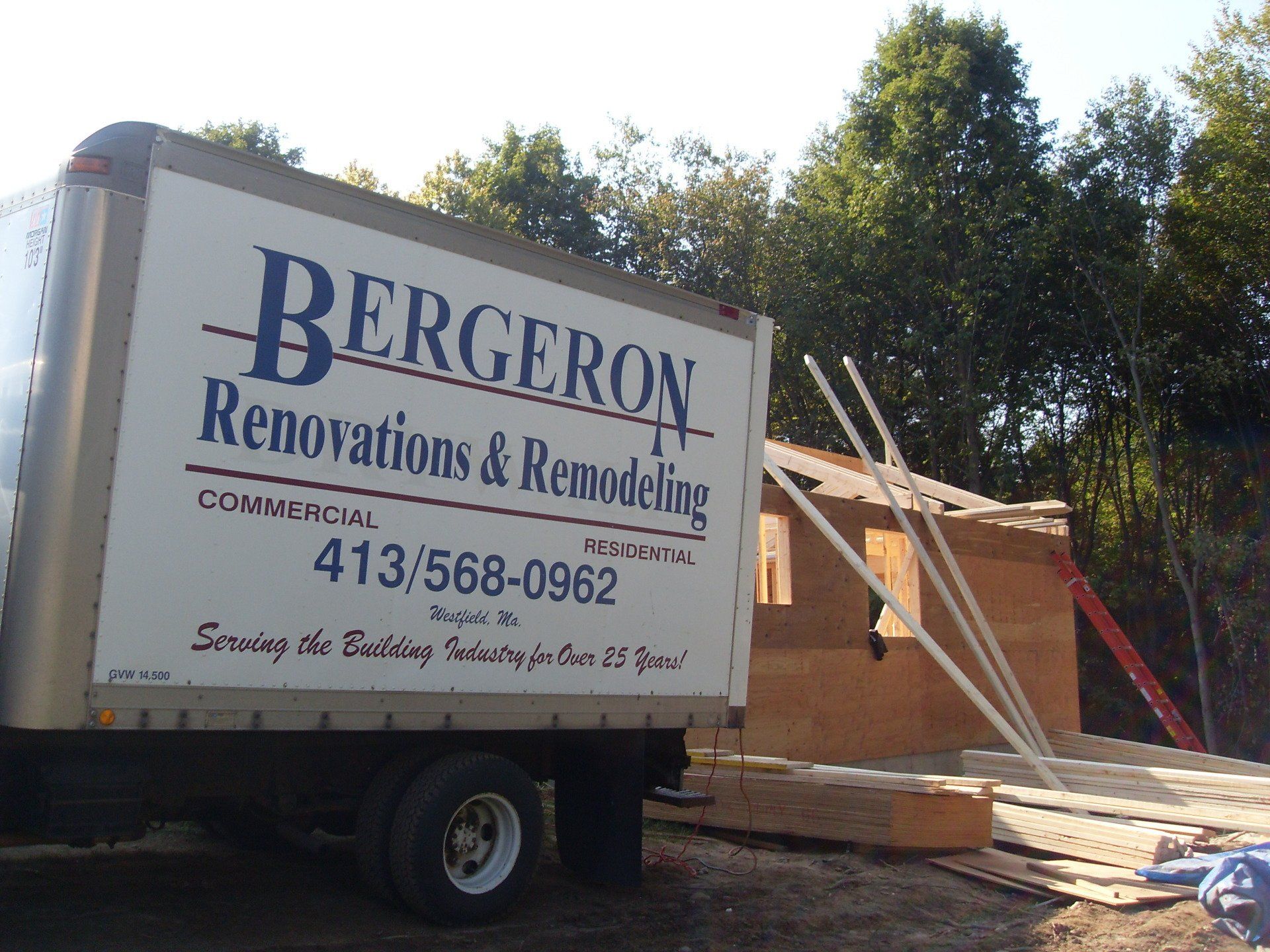 A bergeron renovations and remodeling truck is parked in front of a house under construction