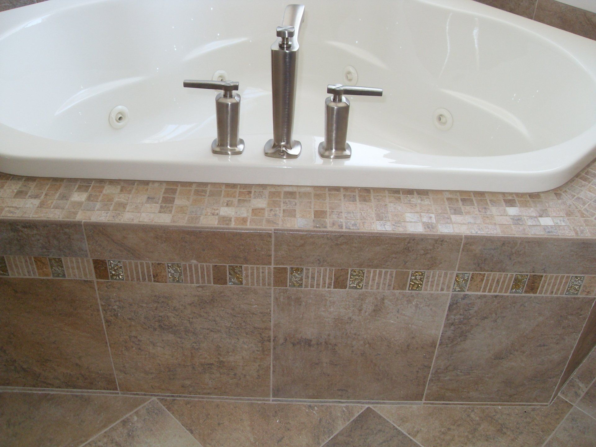 A bathtub with a tiled border and a faucet