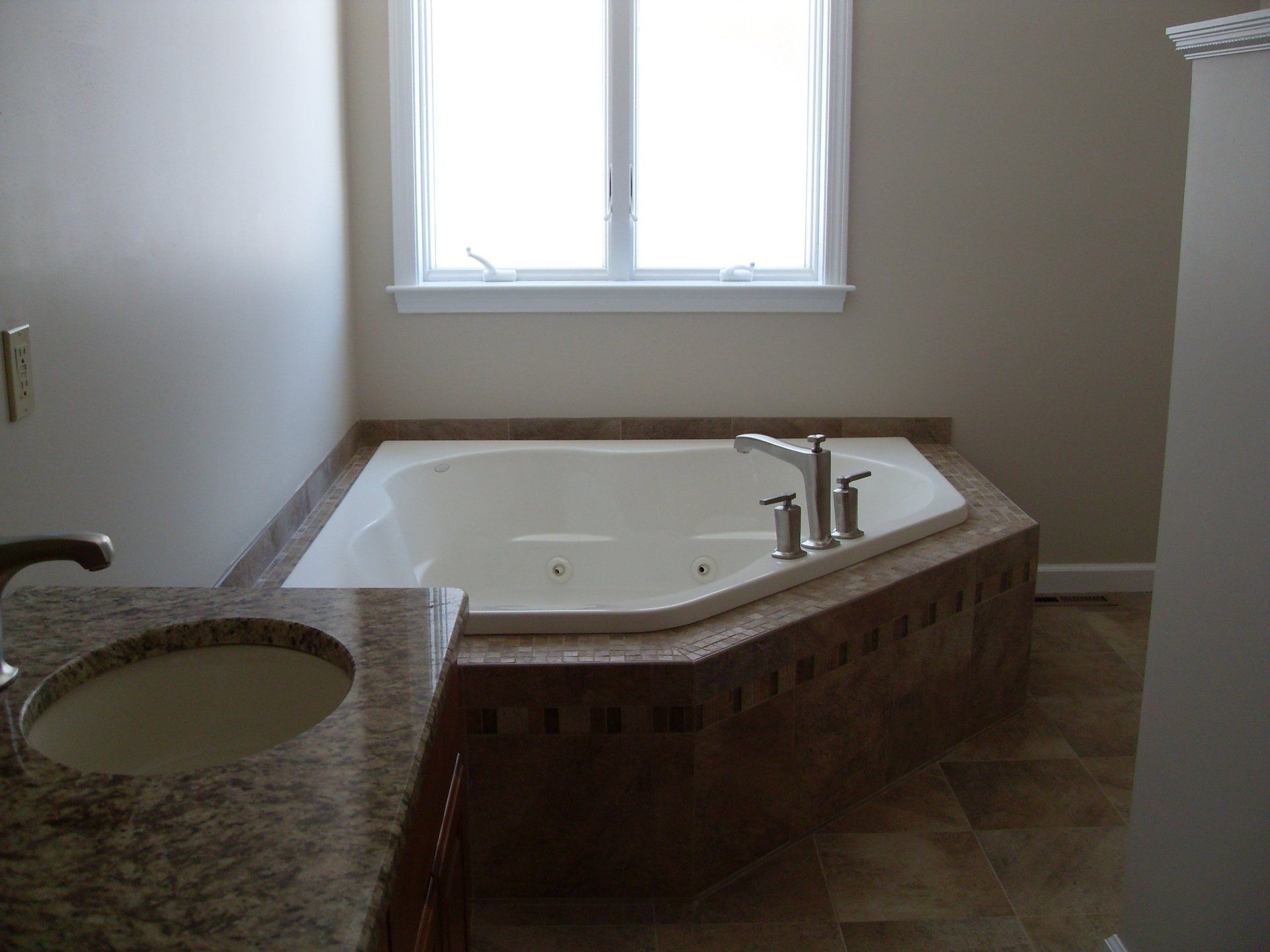 A bathroom with a jacuzzi tub and a sink