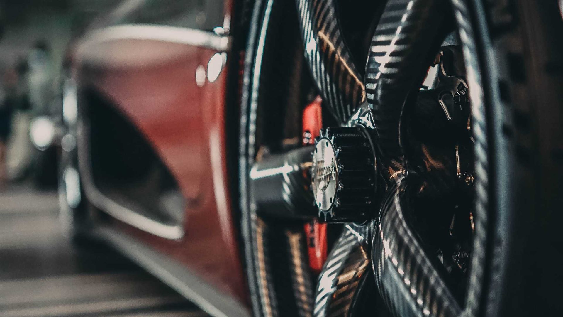 A close up of a car wheel with a red brake caliper.