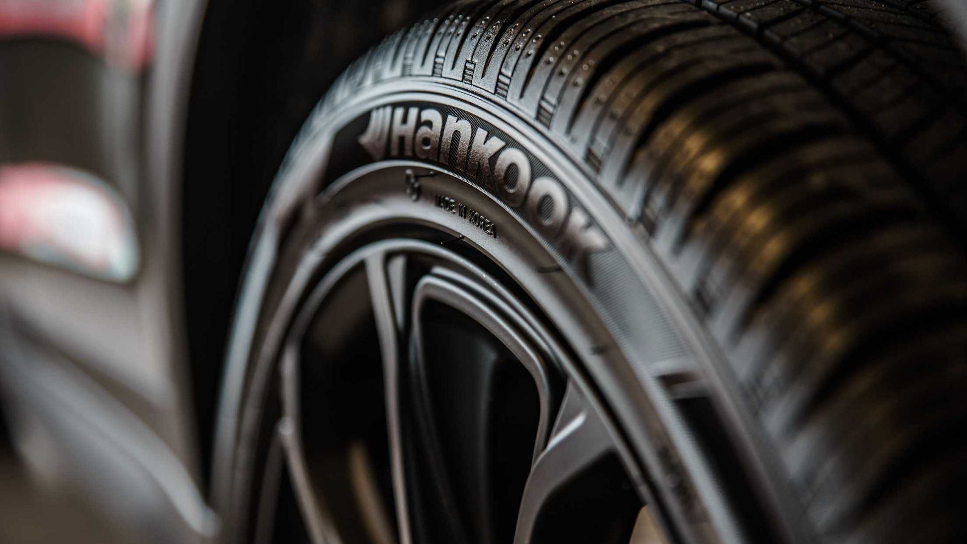 A close up of a hankook tire on a car wheel.