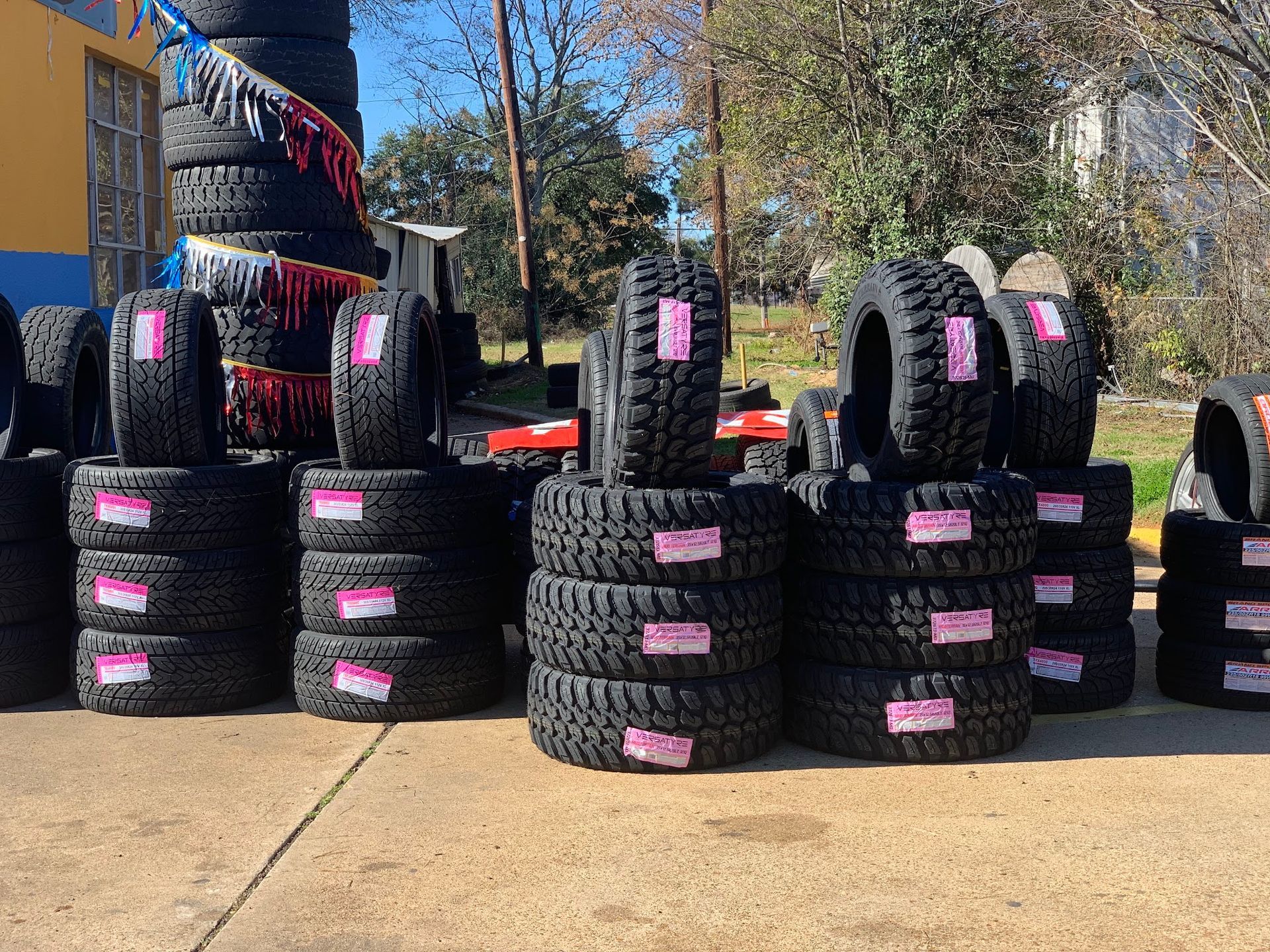 A bunch of tires are stacked on top of each other in a parking lot.
