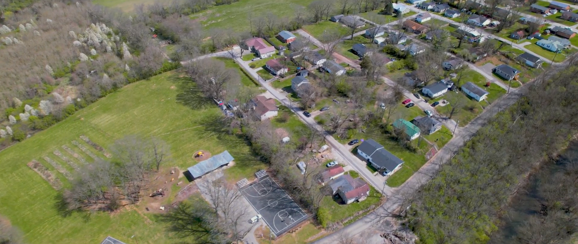 Aerial view of a residential neighborhood with houses, roads, and trees.