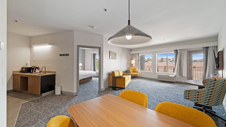 A hotel room with a table and chairs in it.