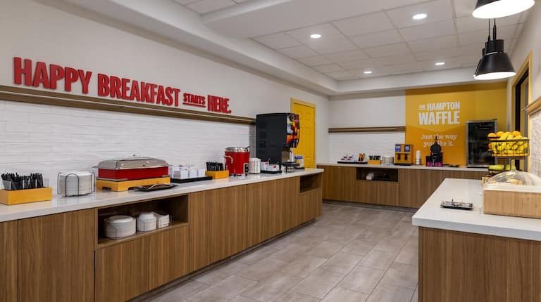 A restaurant with a long counter and a sign that says happy breakfast.