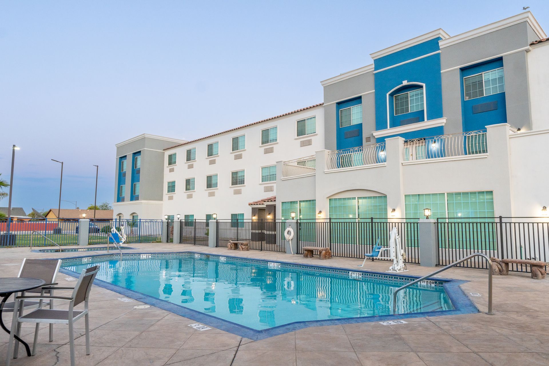 A hotel with a large swimming pool in front of it