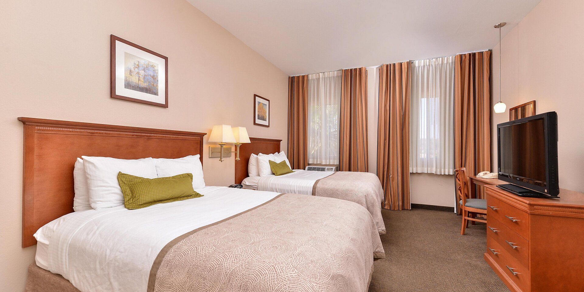 view to two comfortable hotel beds with two lamps in the middle