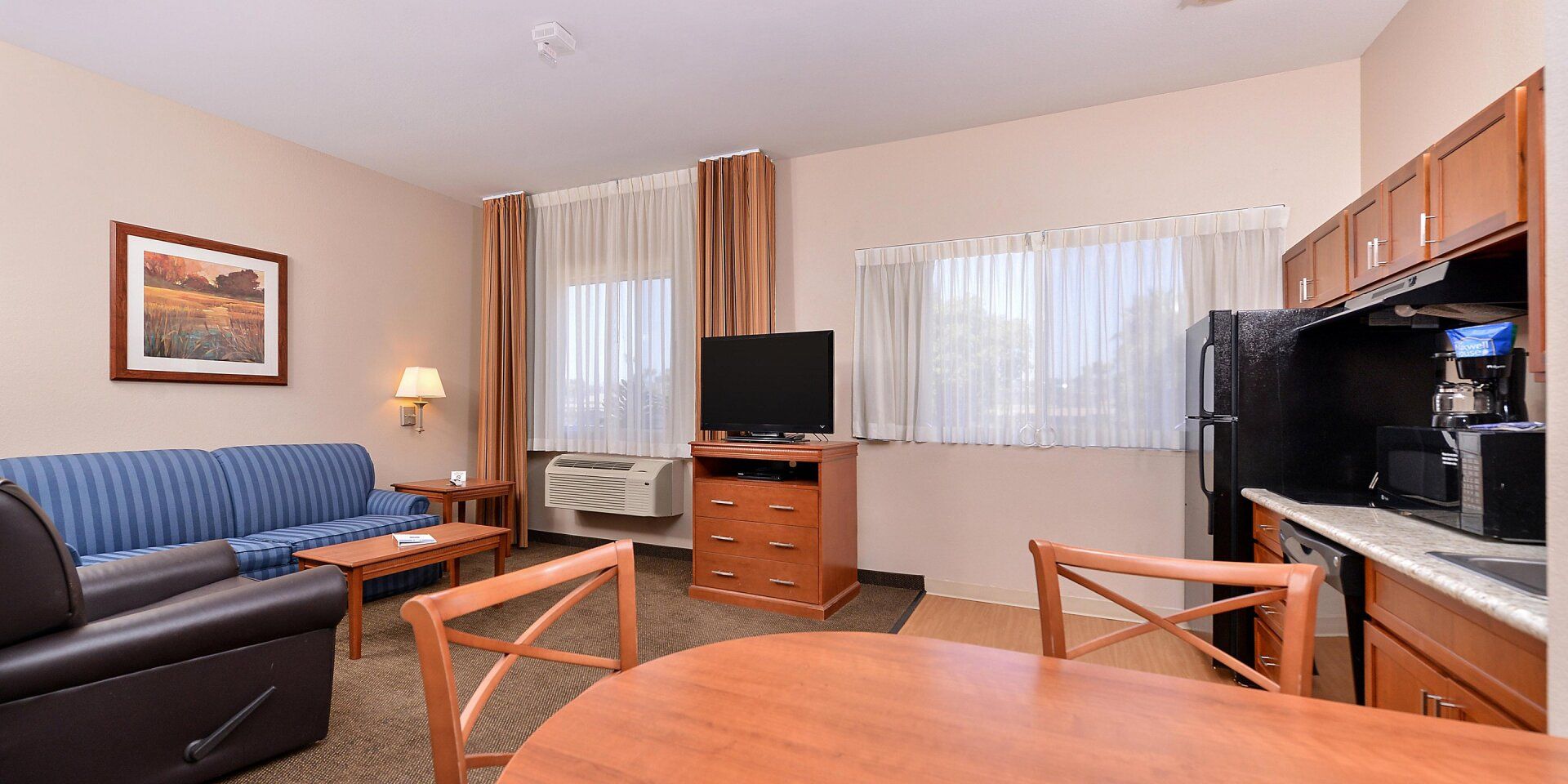 hotel living room view with tables, couch, and television