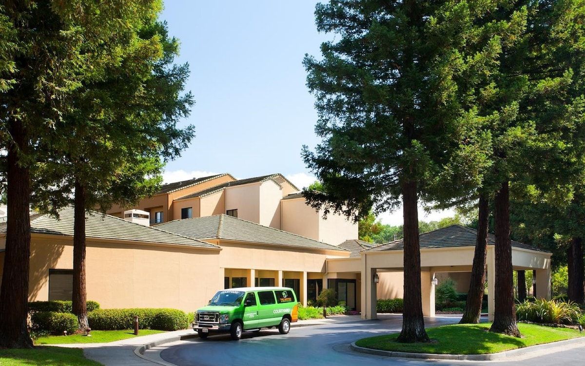 A green van is parked in front of a building