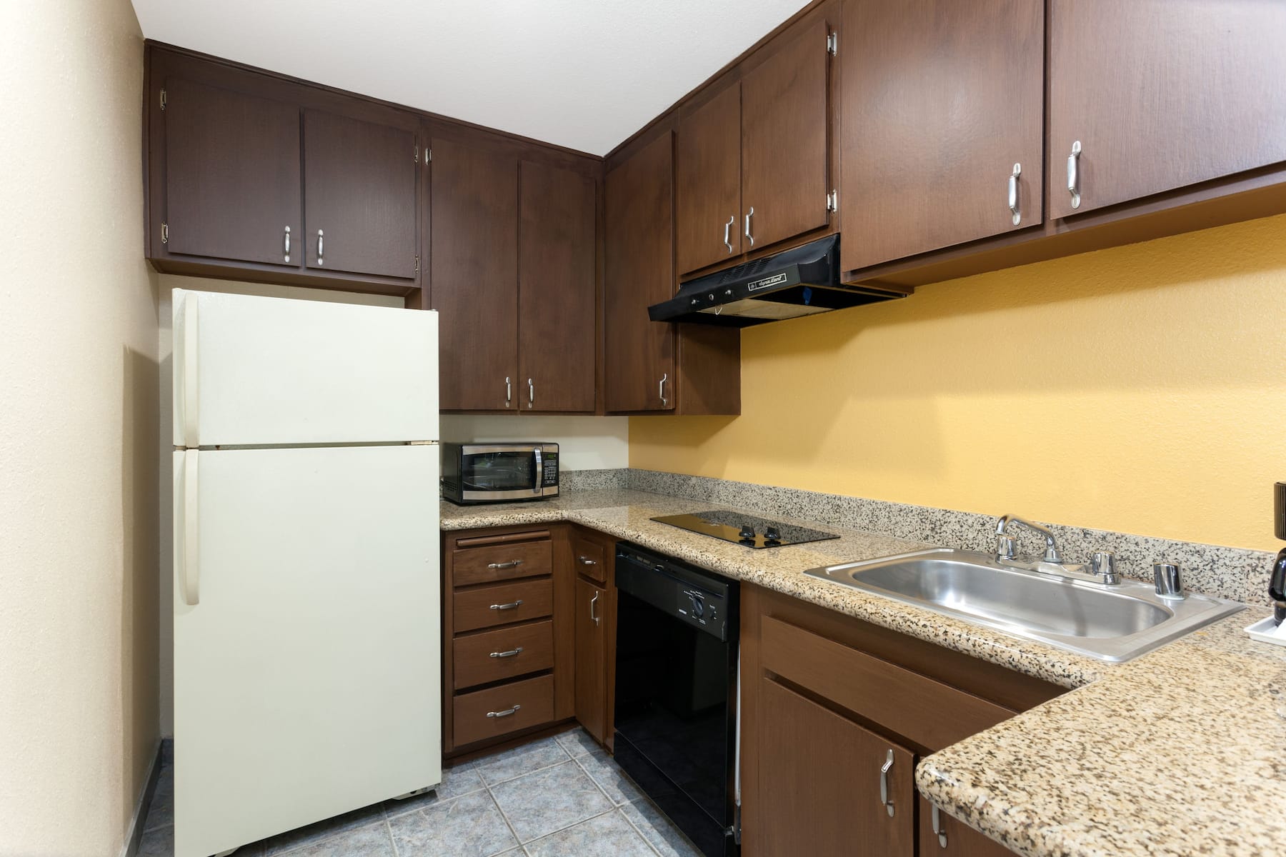 Hotel small kitchen view with fridge and dish washing area