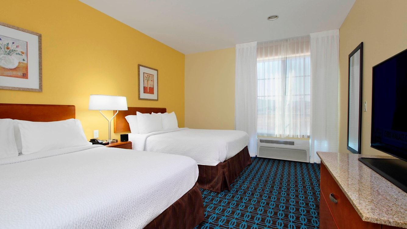 view to the hotel bed with yellow walls and white curtains