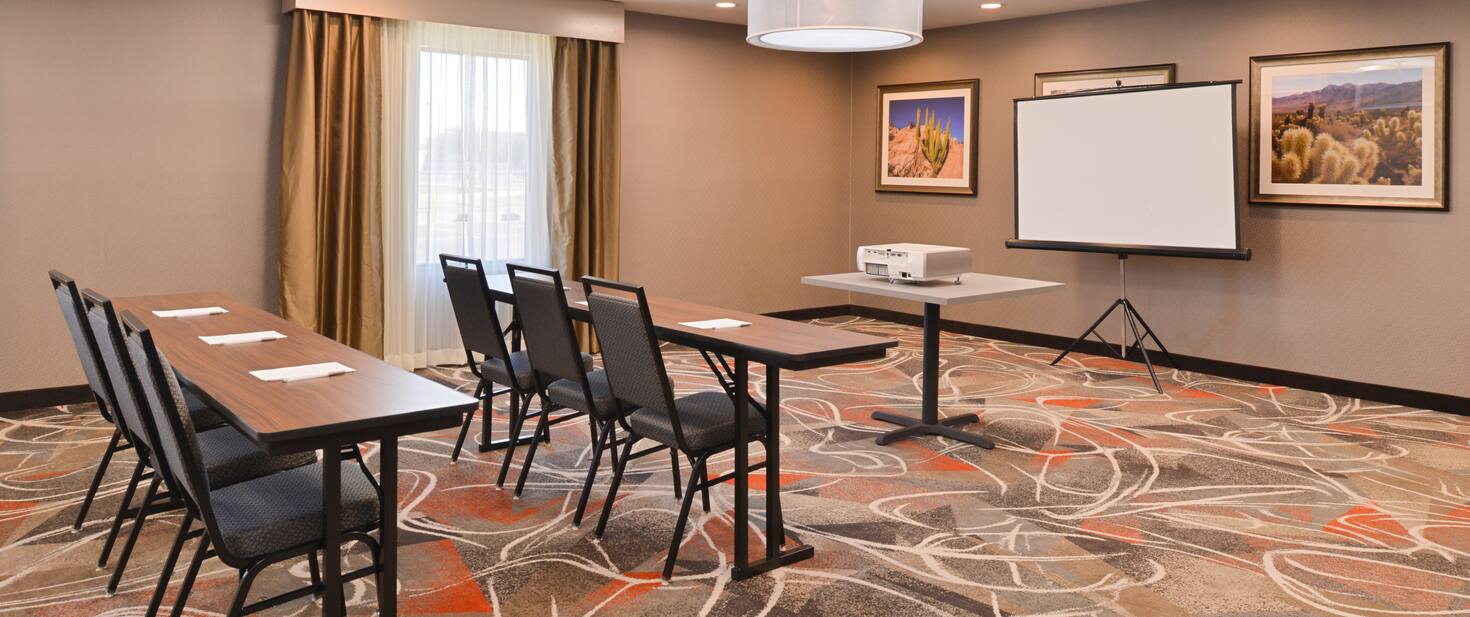 view to the hotel business room with tables and a projector