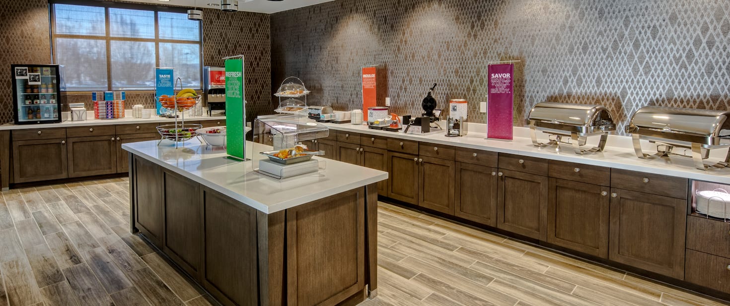 hotel breakfast area with fruits and beverages on the countertop