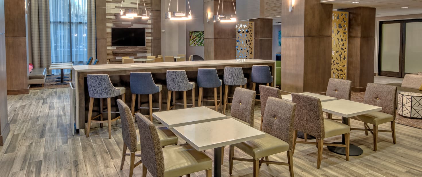 view of the hotel lounge area with multiple tables and chairs