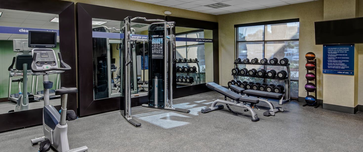 hotel fitness room with cardio machine and dumbells