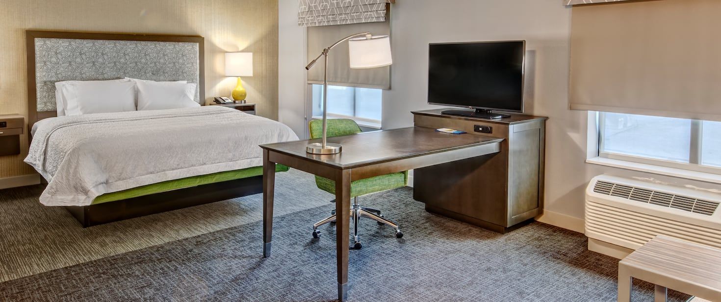 view to the hotel bed and desk with a decorative light