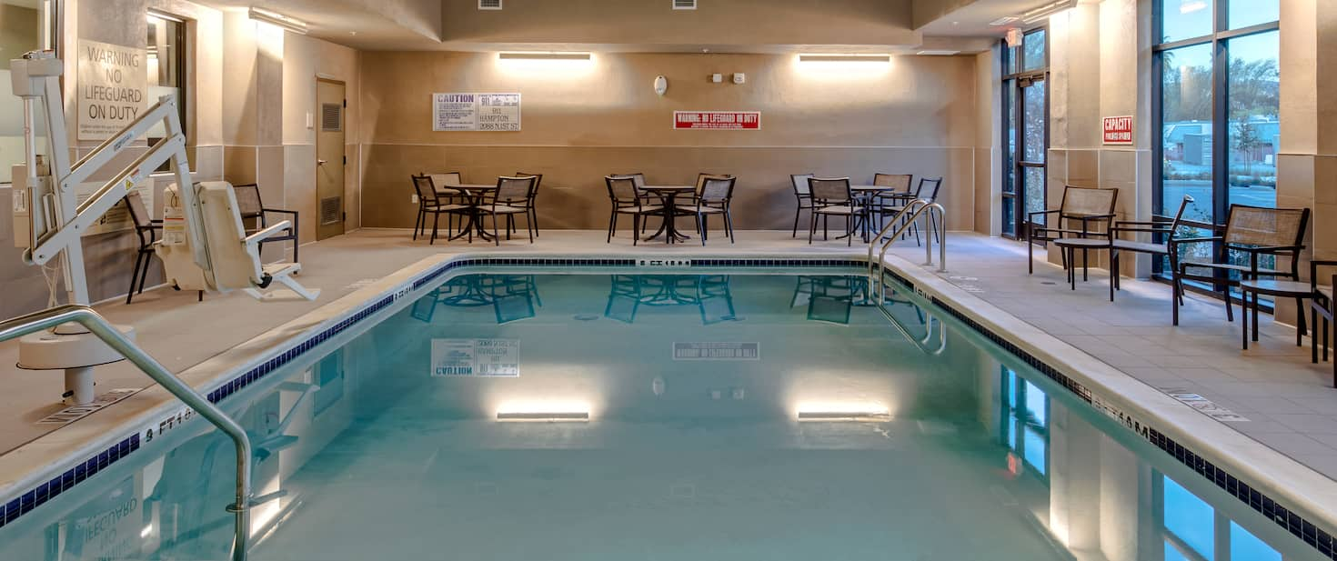 view to the hotel indoor pool with tables and chairs nearby