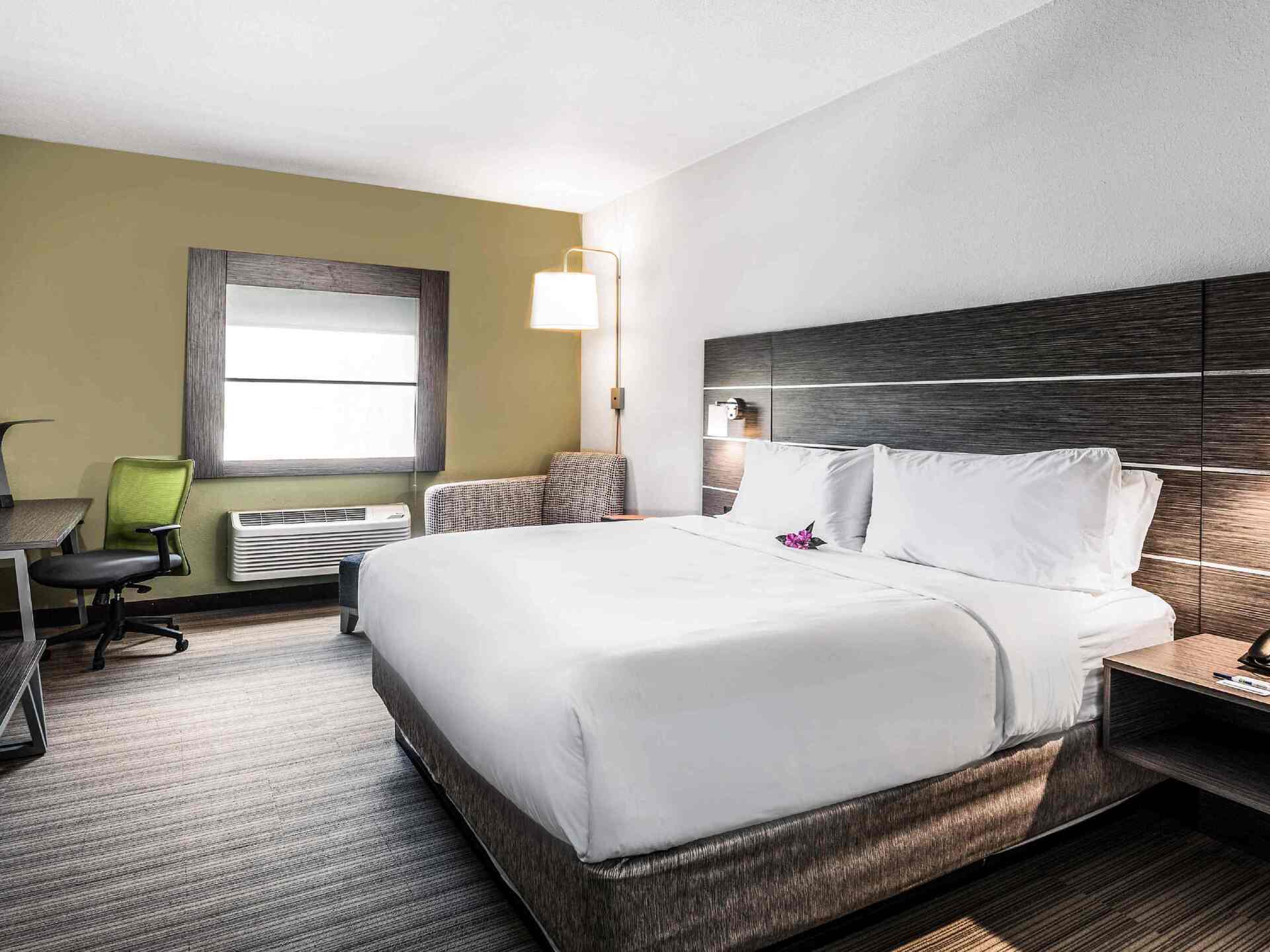 view to the hotel bed with white sheets and green wall