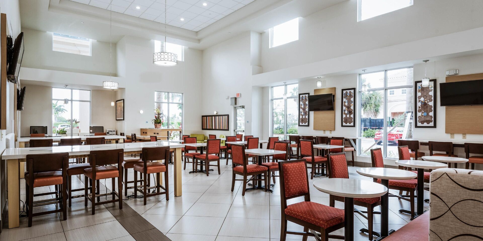 view of the hotel lobby with multiple tables and orange chairs