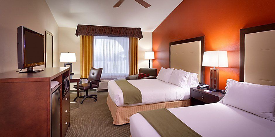 view to the hotel beds with green decorative sheet and large window