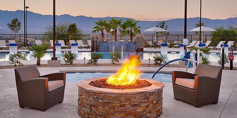 outdoor hotel bonfire with chairs and pool nearby