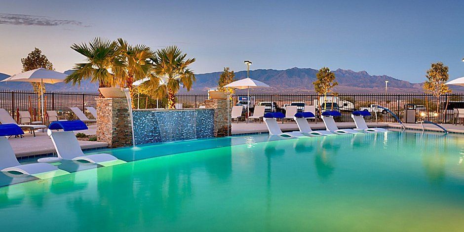 view to the outdoor pool with lounge chairs and the mountains in the background