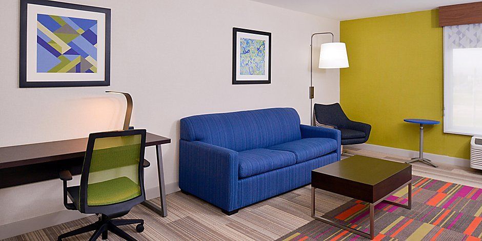 view to the hotel living room area with a blue couch and a coffee table