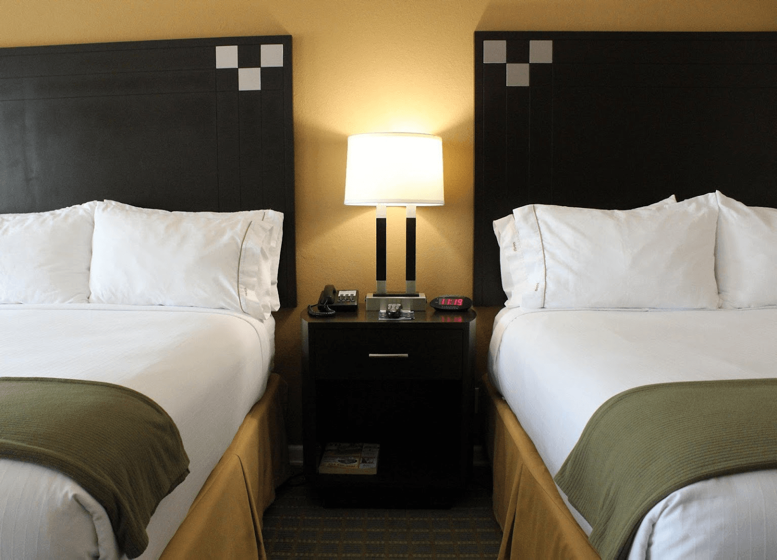 close up view of the comfortable hotel beds with a lamp in the middle