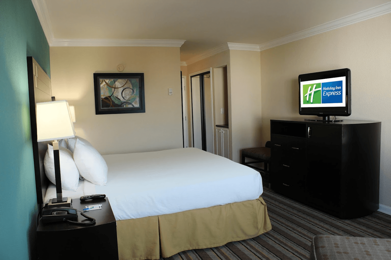 view to the hotel bed with a television showing the holiday inn logo