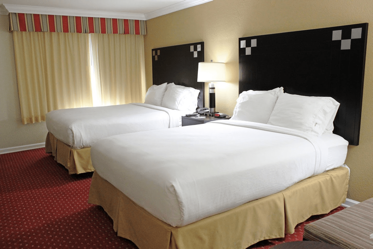 view to the two hotel beds with decorative curtains on the window