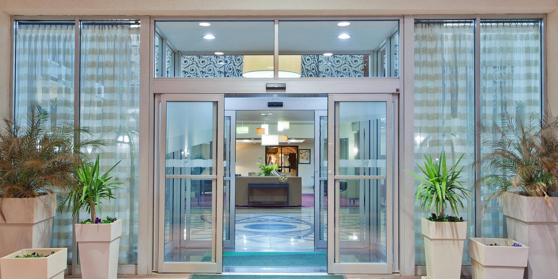 Hotel front entrance doors open with a view inside the hotel