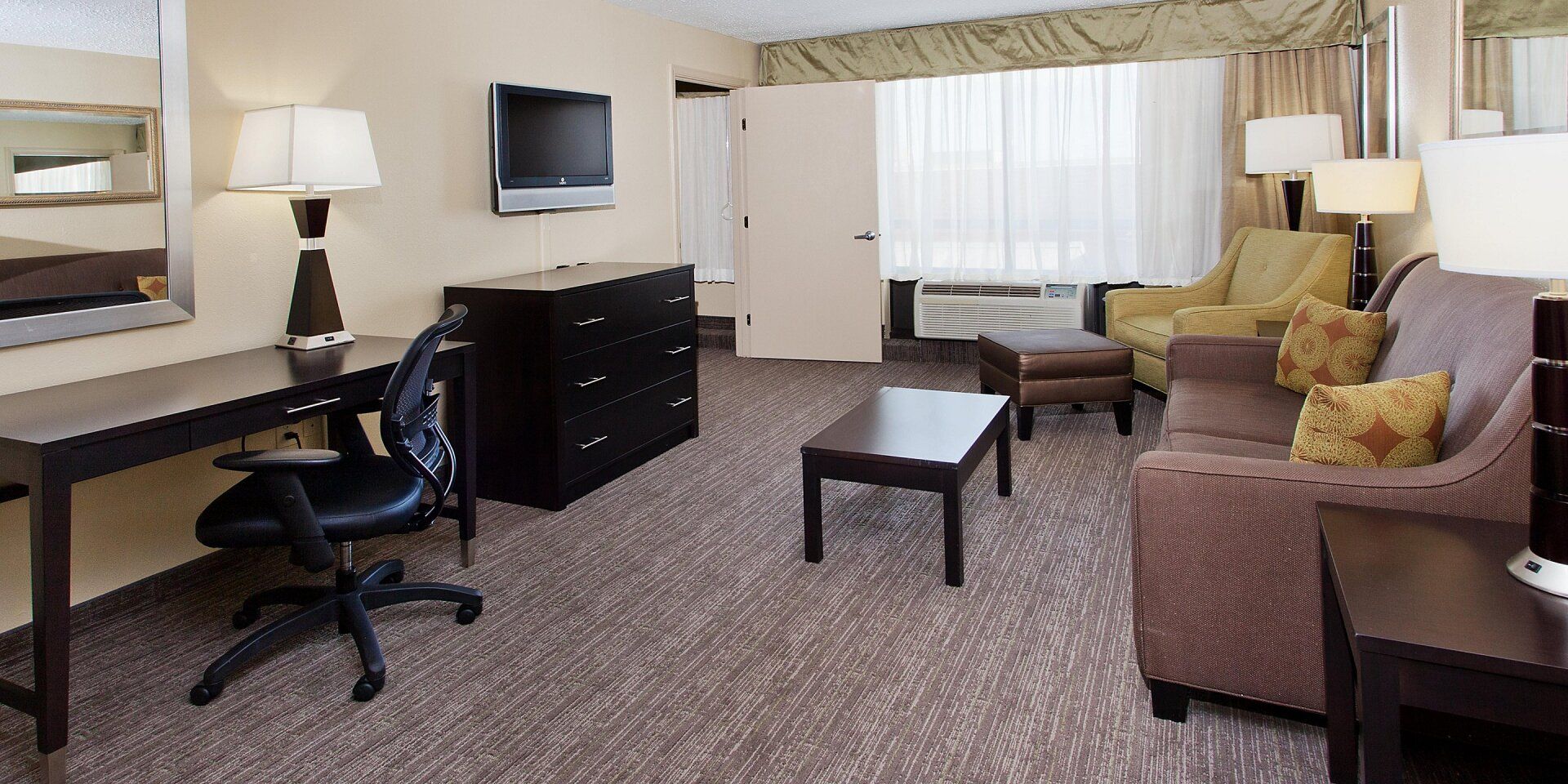 hotel living room area with two couches, coffee table, and television