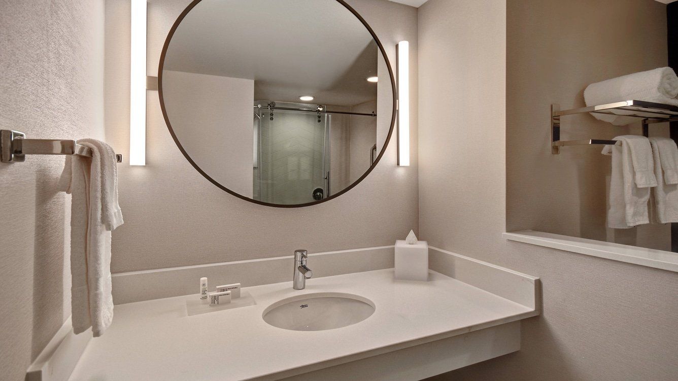 hotel bathroom with a large mirror and a sink