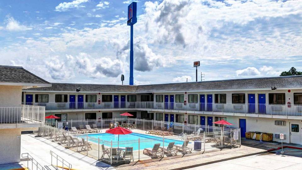 Exterior view of the hotel showing the rooms, pool area, and the Motel 6 sign