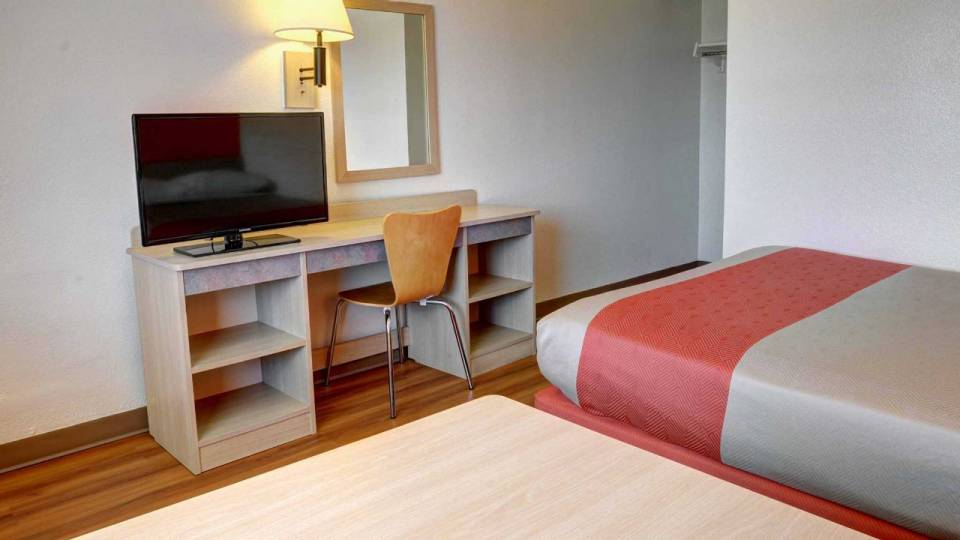 Hotel room view of the bed, chair and television