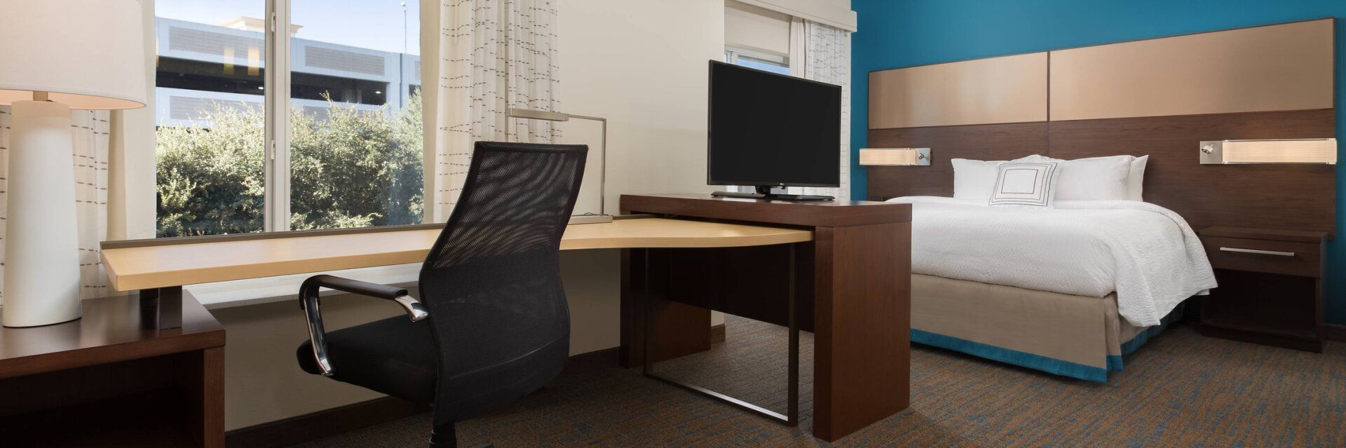 Close up with hotel room desk area with a bed in the background