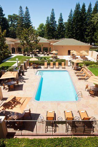 An aerial view of a large swimming pool surrounded by chairs and umbrellas