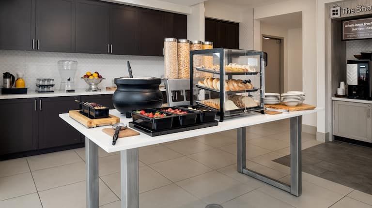 There is a table with a lot of food on it in the kitchen.