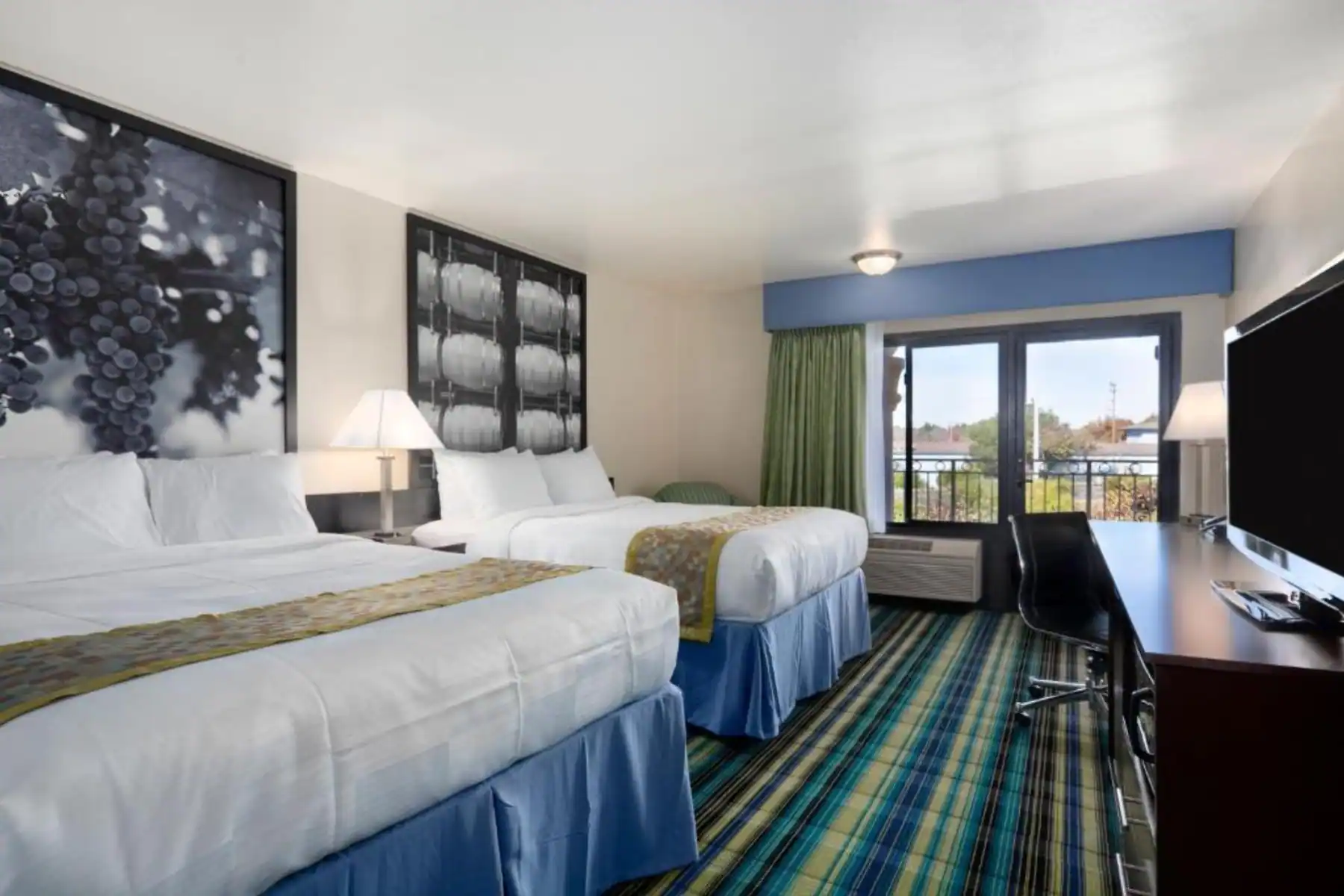 view to the hotel beds with wall decorations and a window view to the outside