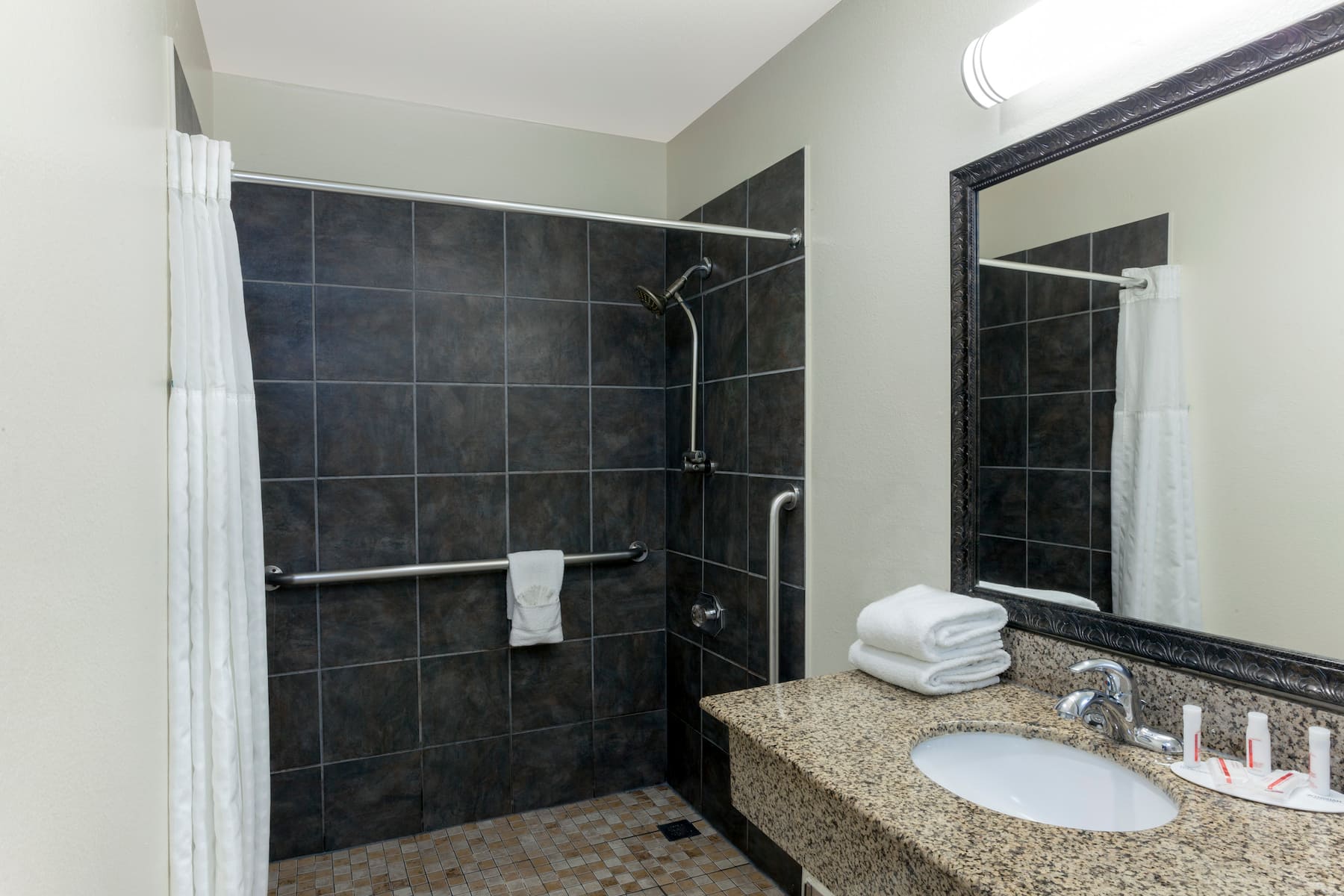 Hotel bathroom with a large shower and a sink