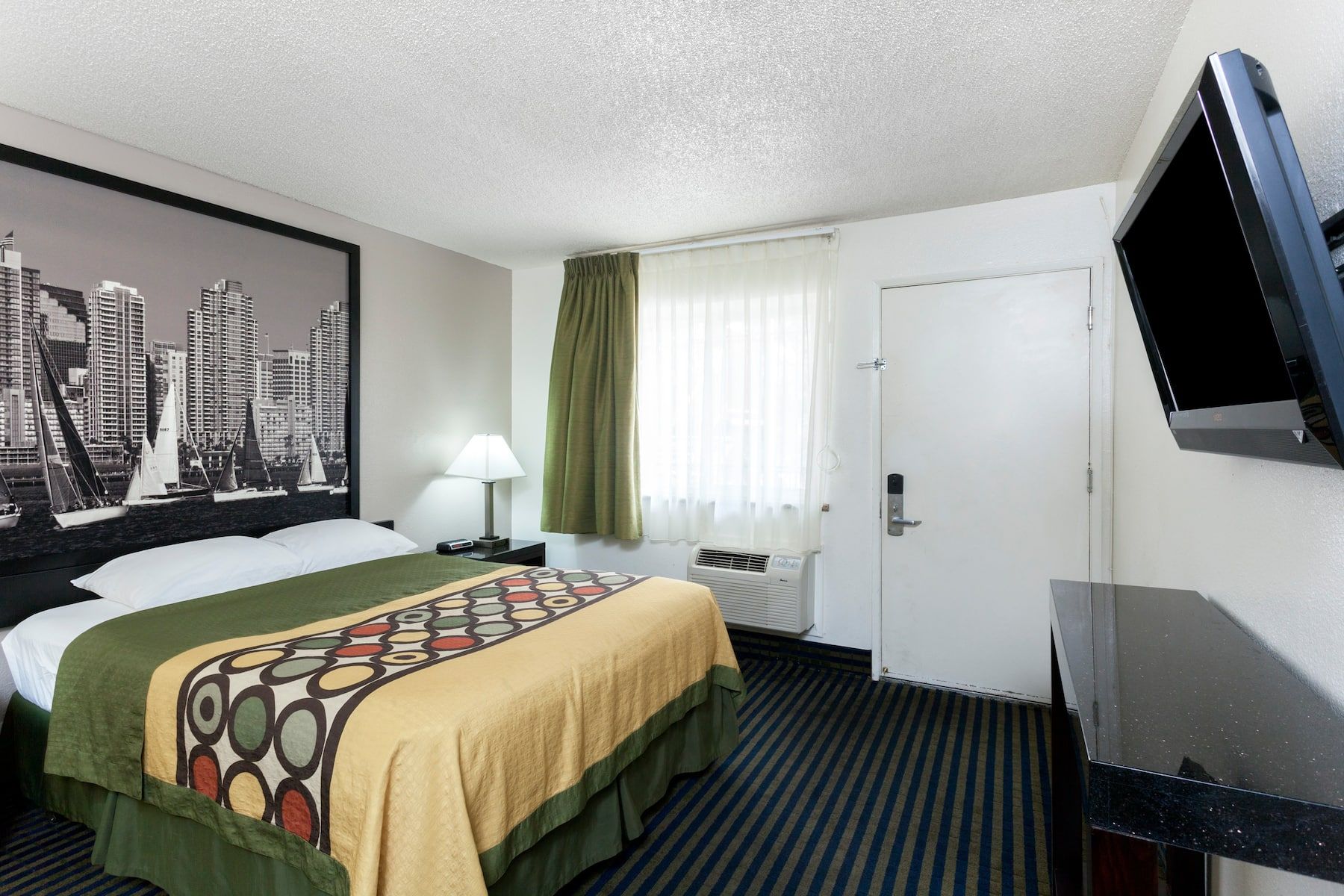 View of hotel room entrance leading to hotel bed and television