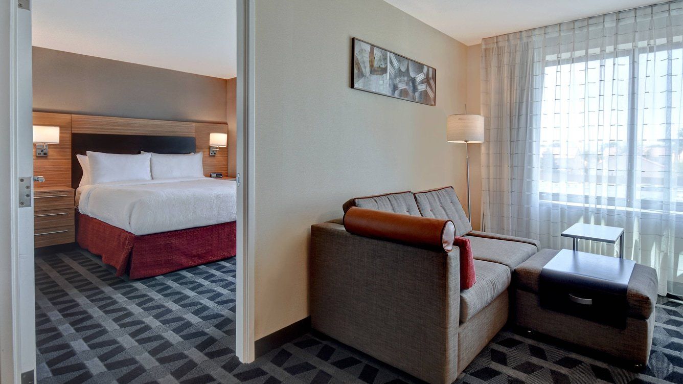 close up of a brown hotel couch with the bedroom in the background